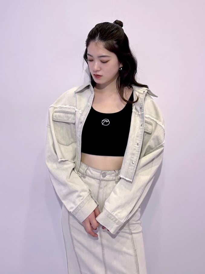 ホワイト系のデニムジャケット、ホワイト系のスカート、ブラック系のブーツを着用したレディースの夏コーディネートの5枚目の写真