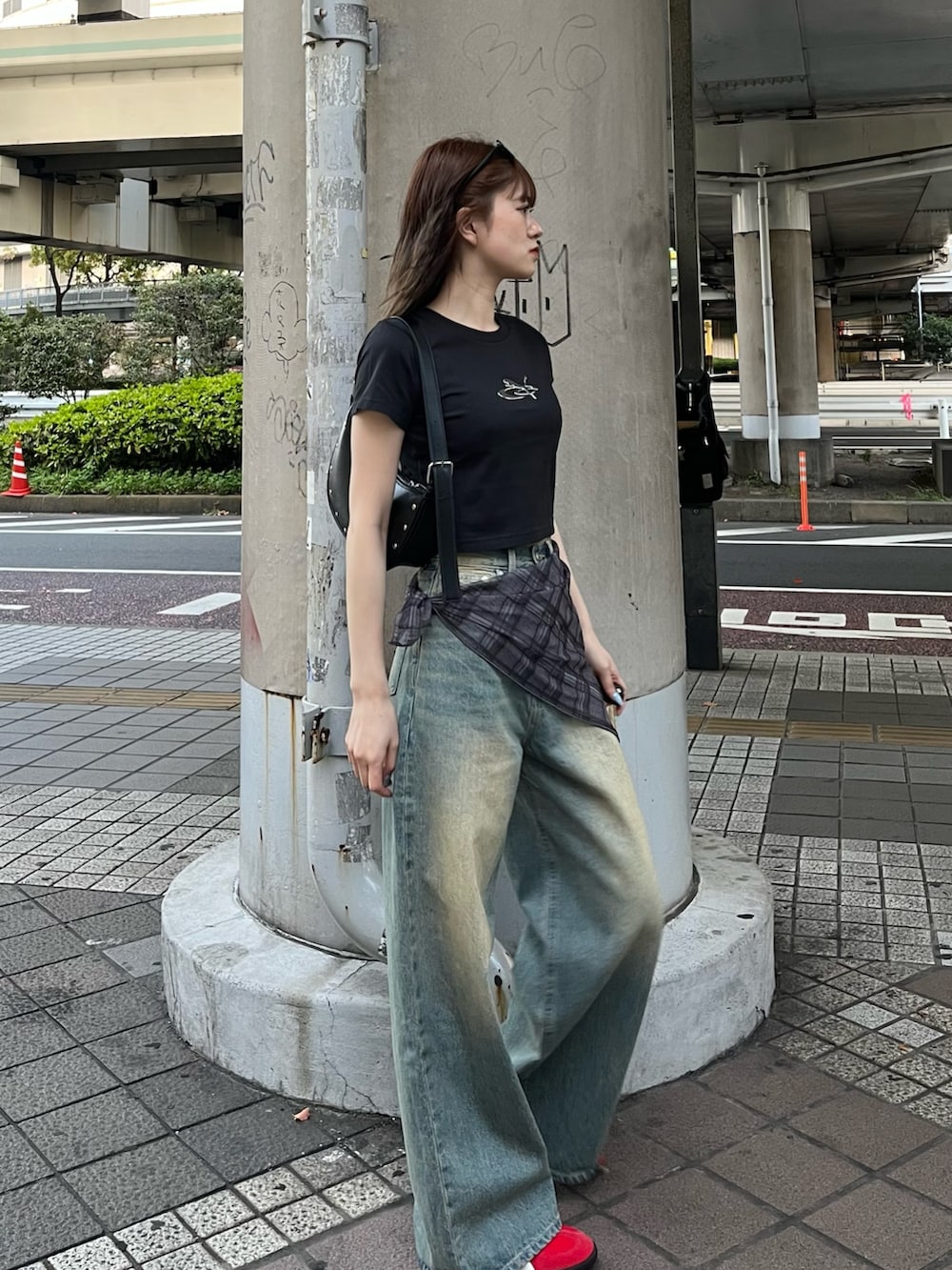 ブラック系のTシャツ/カットソー、ブラック系のハンドバッグ、ブルー系のデニムパンツを着用したレディースの春コーディネートの2枚目の写真