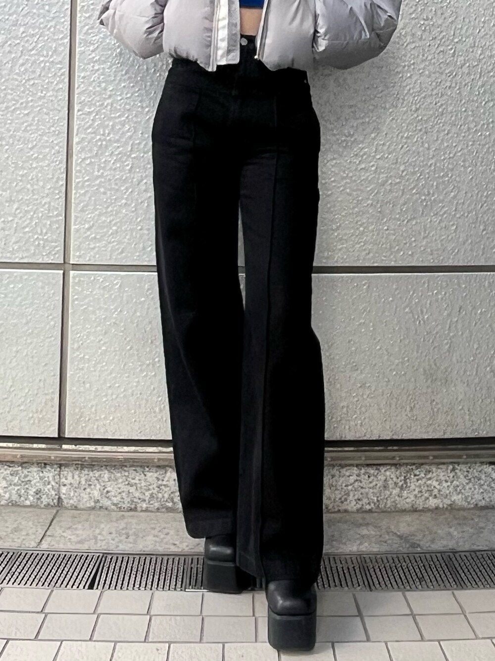 ブラック系のデニムパンツ、ブルー系のニット/セーター、グレー系のダウンジャケット/コートを着用したレディースの冬コーディネートの7枚目の写真