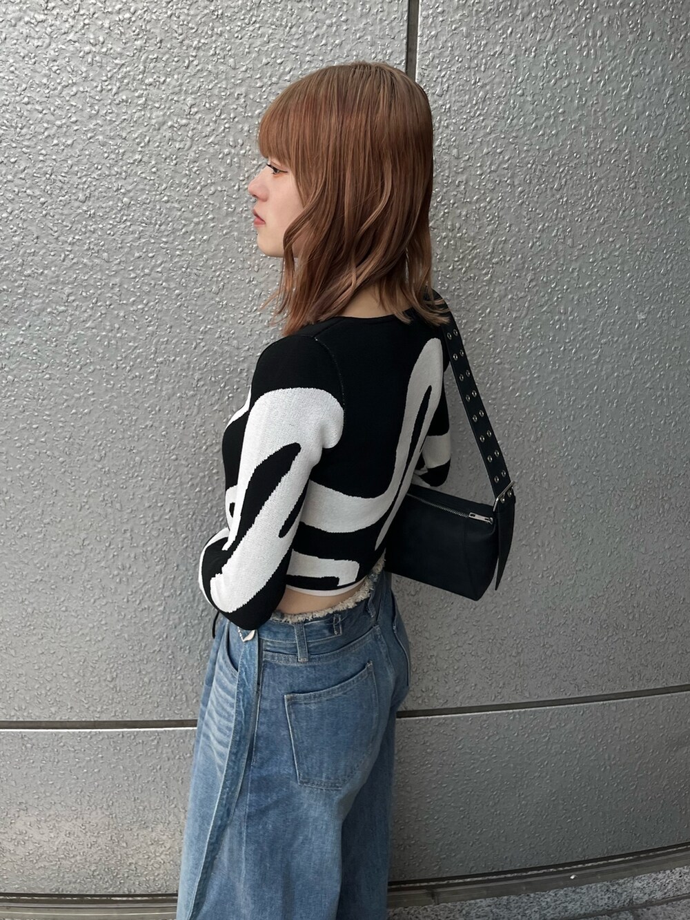 ブラック系のスニーカー、ブルー系のデニムパンツ、ホワイト系のキャミソールを着用したレディースの冬コーディネートの6枚目の写真