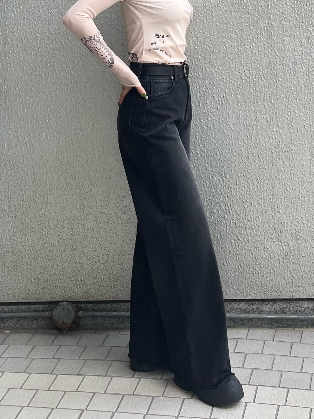 ブラック系のブーツ、ブラック系のデニムパンツ、ホワイト系のTシャツ/カットソーを着用したレディースの秋コーディネートの6枚目の写真