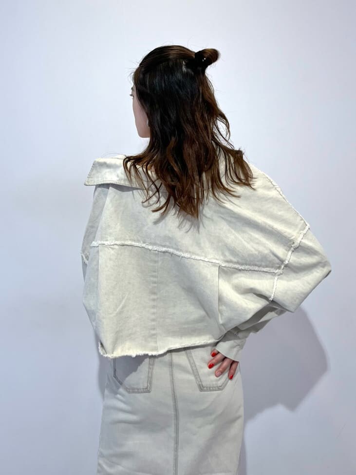 ホワイト系のデニムジャケット、ホワイト系のスカート、ブラック系のブーツを着用したレディースの夏コーディネートの6枚目の写真