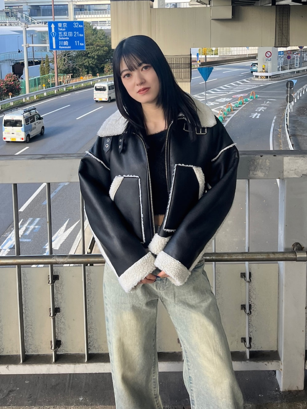 ブルー系のデニムパンツ、ブラック系のニット/セーター、ブラック系のブーツを着用したレディースの冬コーディネートの7枚目の写真