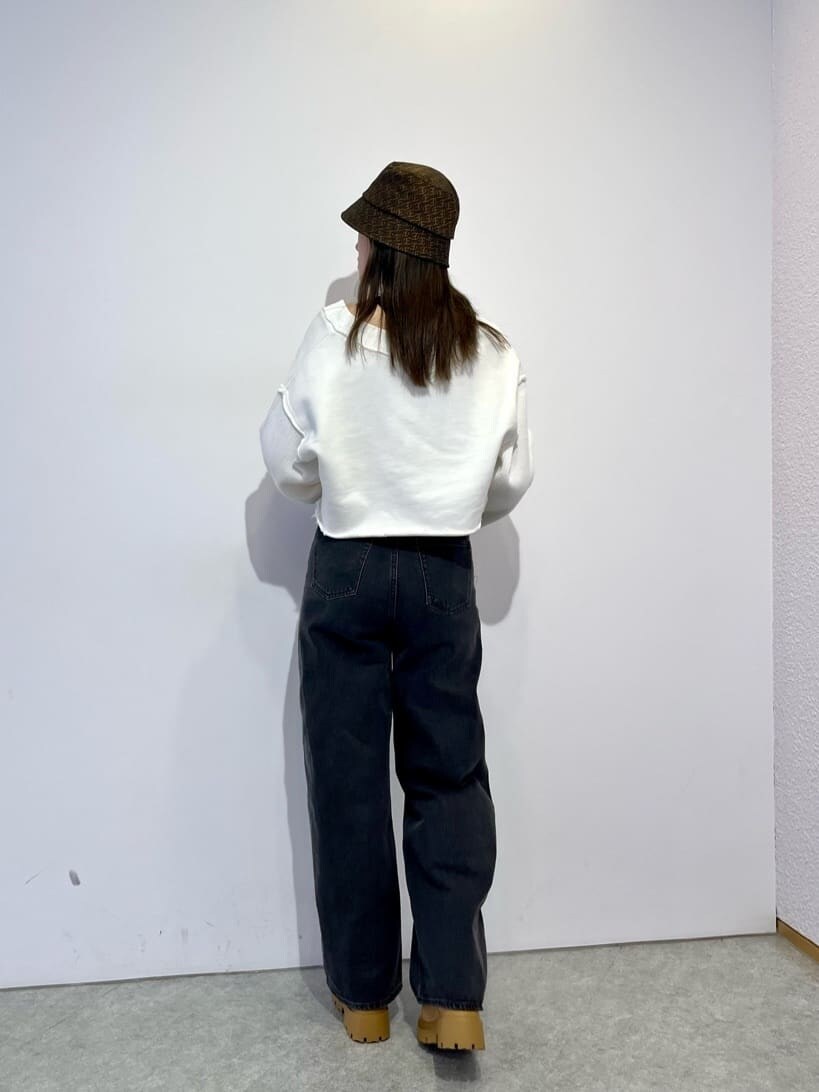 ブラウン系のブーツ、ホワイト系のカーディガン/ボレロ、グレー系のデニムパンツを着用したレディースの秋コーディネートの4枚目の写真