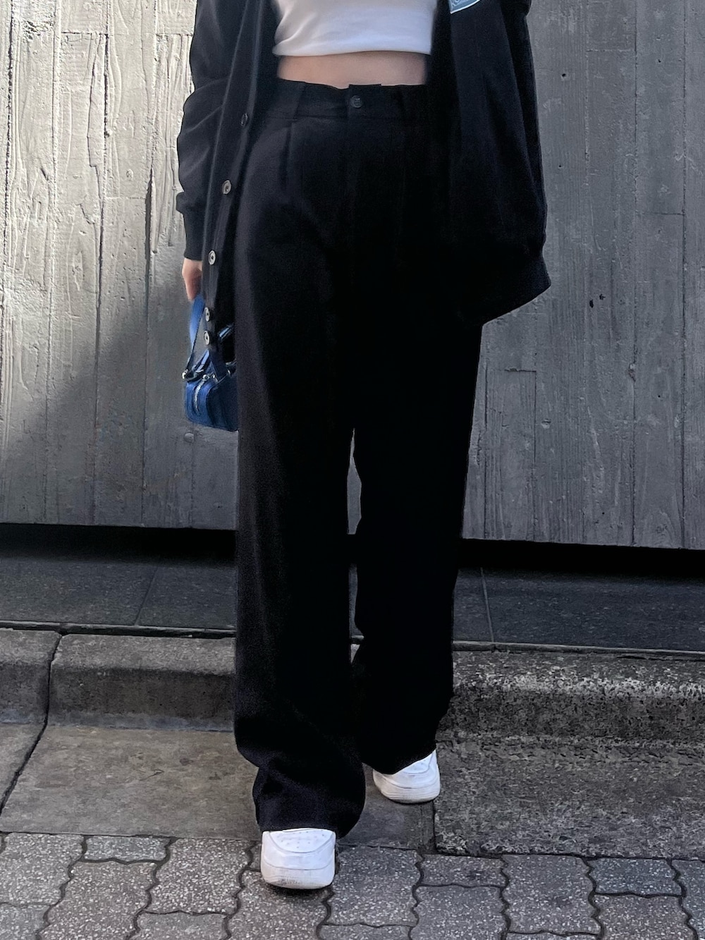 ホワイト系のキャミソール、ブラック系のカーディガン/ボレロ、ブルー系のハンドバッグを着用したレディースの春コーディネートの6枚目の写真