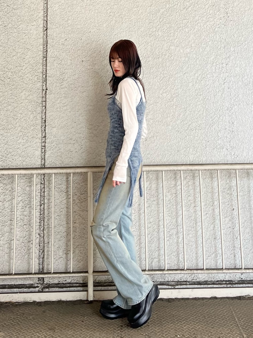 ブルー系のニット/セーター、ホワイト系のTシャツ/カットソー、ブルー系のデニムパンツを着用したレディースの春コーディネートの2枚目の写真