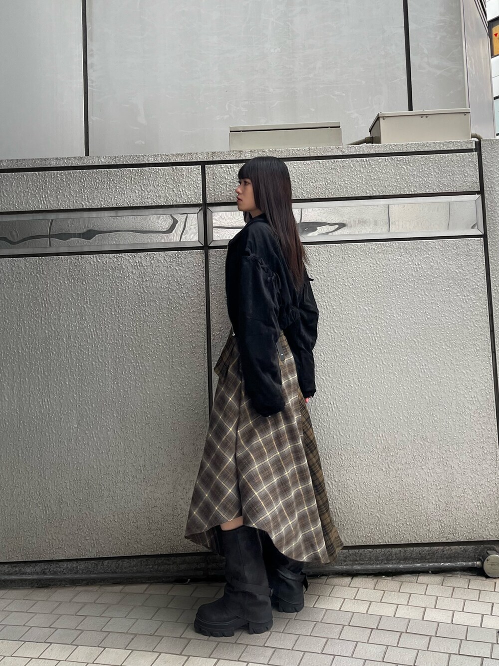 グリーン系のスカート、ブラック系のTシャツ/カットソー、ブラック系のブルゾンを着用したレディースの秋コーディネートの3枚目の写真