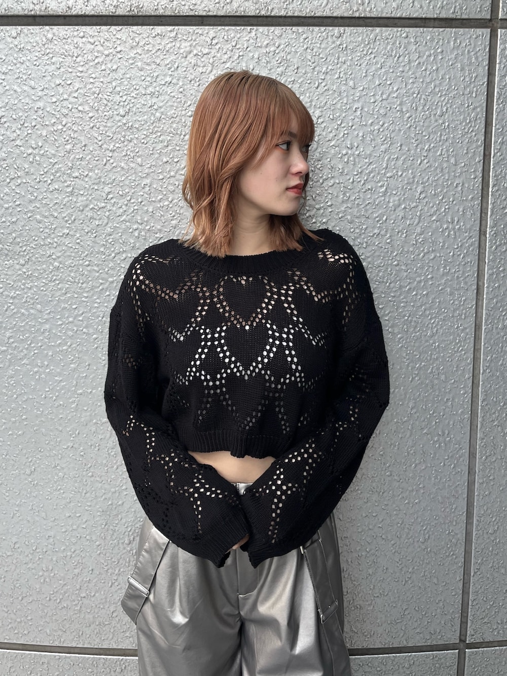 ブラック系のスニーカー、ブラック系のニット/セーター、ホワイト系のキャミソールを着用したレディースの冬コーディネートの5枚目の写真