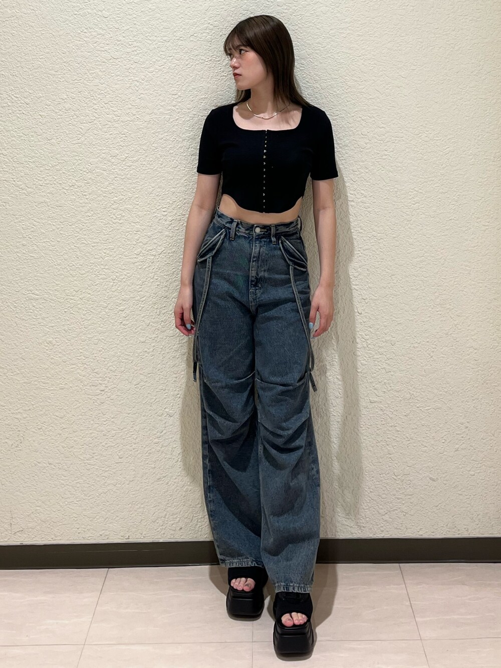 ブルー系のデニムパンツ、ブラック系のTシャツ/カットソー、ブラック系のサンダルを着用したレディースの夏コーディネートの2枚目の写真