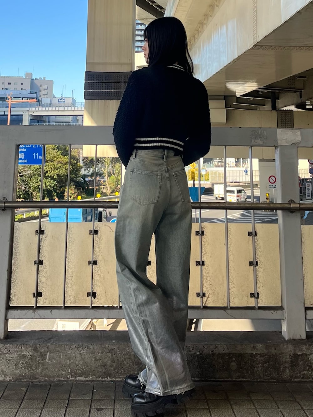 ブルー系のデニムパンツ、ブラック系のブーツ、ブラック系のカーディガン/ボレロを着用したレディースの冬コーディネートの2枚目の写真