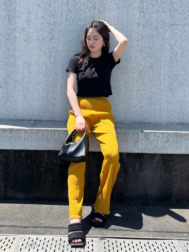 イエロー系のその他パンツ、ブラック系のTシャツ/カットソー、ブラック系のサンダルを着用したレディースの夏コーディネートの2枚目の写真