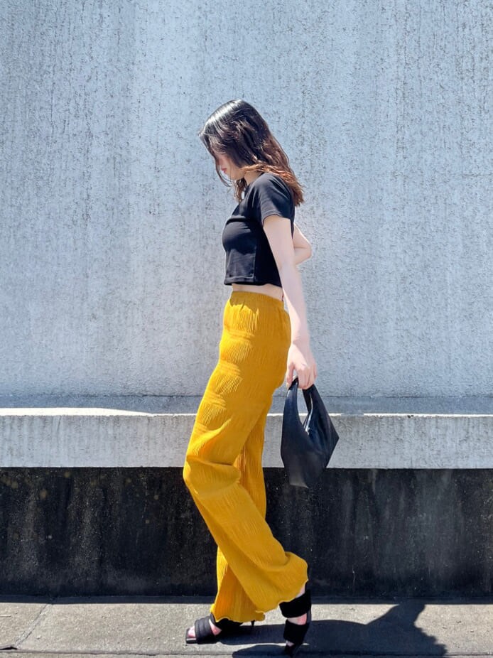 イエロー系のその他パンツ、ブラック系のTシャツ/カットソー、ブラック系のサンダルを着用したレディースの夏コーディネートの3枚目の写真
