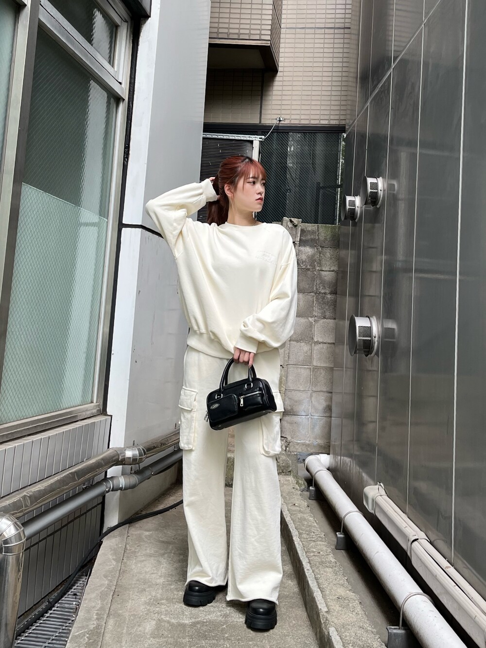 ホワイト系のTシャツ/カットソー、ホワイト系のその他パンツ、ブラック系のブーツを着用したレディースの秋コーディネートの2枚目の写真