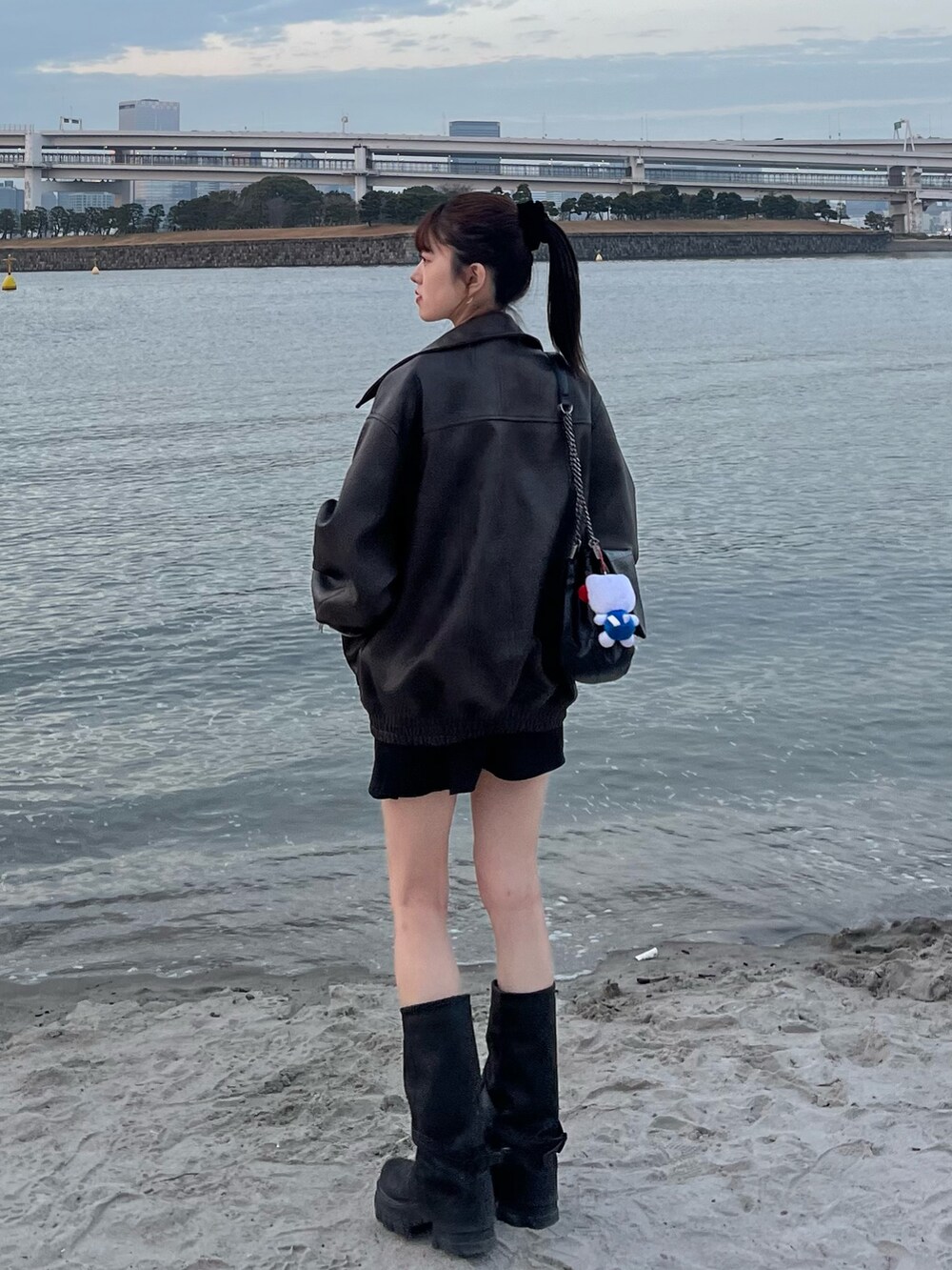 ブラウン系のブルゾン、ホワイト系のシャツ/ブラウス、ブラック系のブーツを着用したレディースの春コーディネートの3枚目の写真