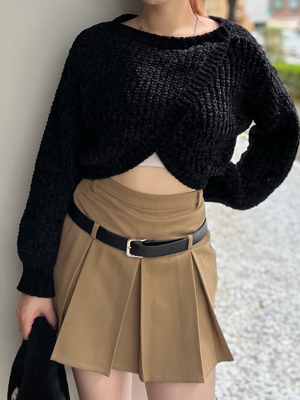 ブラック系のハンドバッグ、ブラック系のニット/セーター、ベージュ系のスカートを着用したレディースの秋コーディネートの7枚目の写真