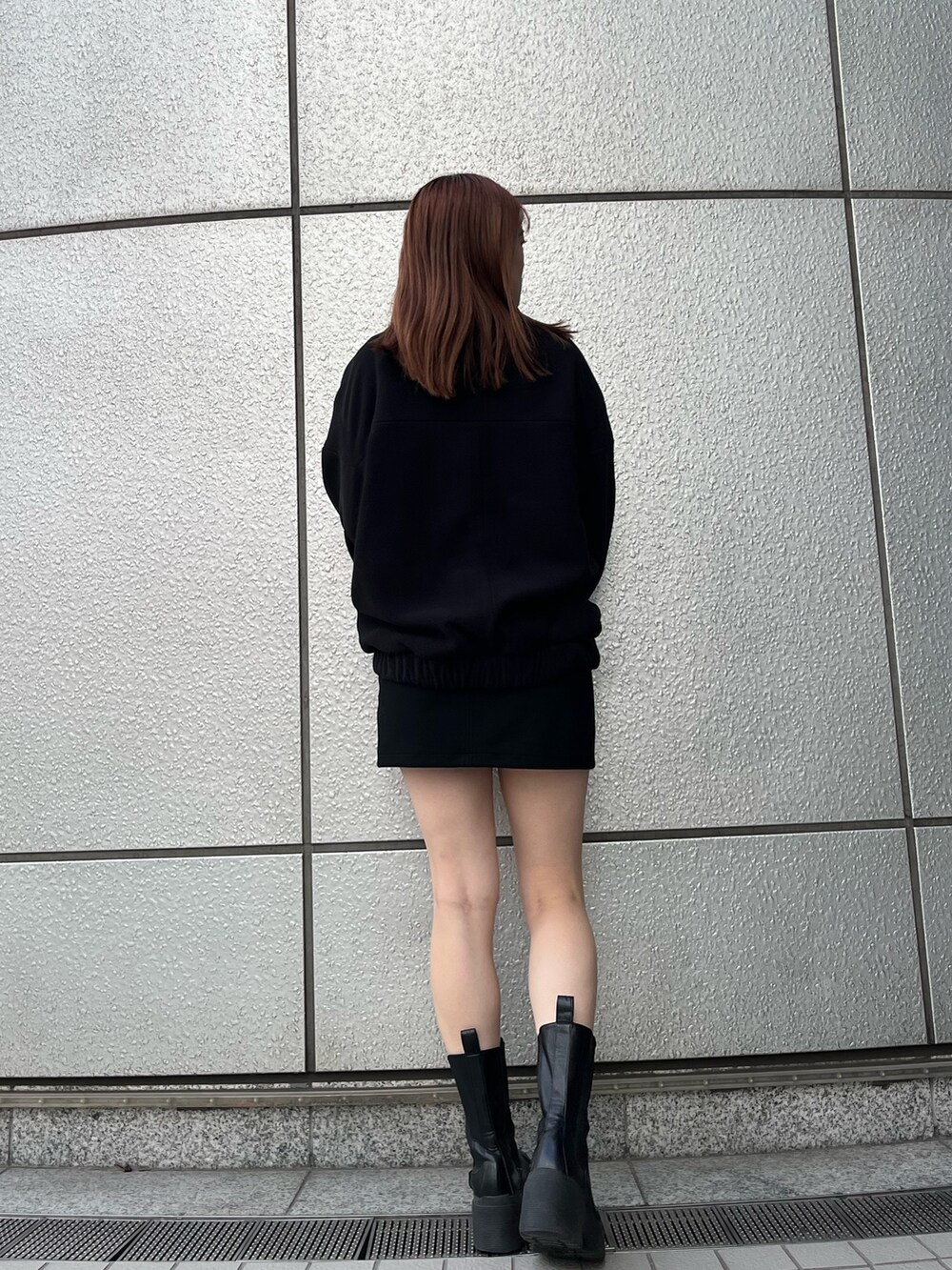 ブラック系のスカート、ブラック系のブーツ、ブラック系のブルゾンを着用したレディースの秋コーディネートの4枚目の写真