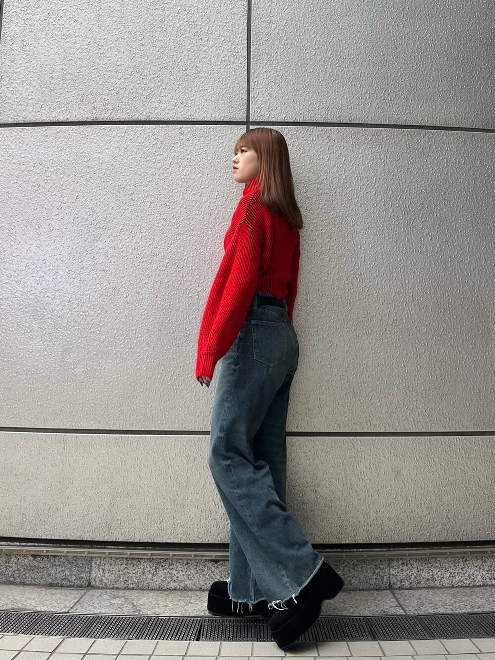 ブラック系のブーツ、ブルー系のデニムパンツ、レッド系のニット/セーターを着用したレディースの秋コーディネートの3枚目の写真