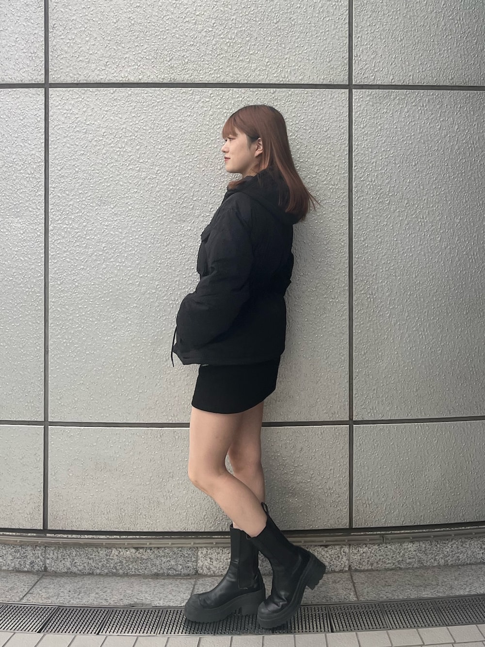 ブラック系のスカート、ブラック系のブーツ、ブラック系のブルゾンを着用したレディースの秋コーディネートの3枚目の写真