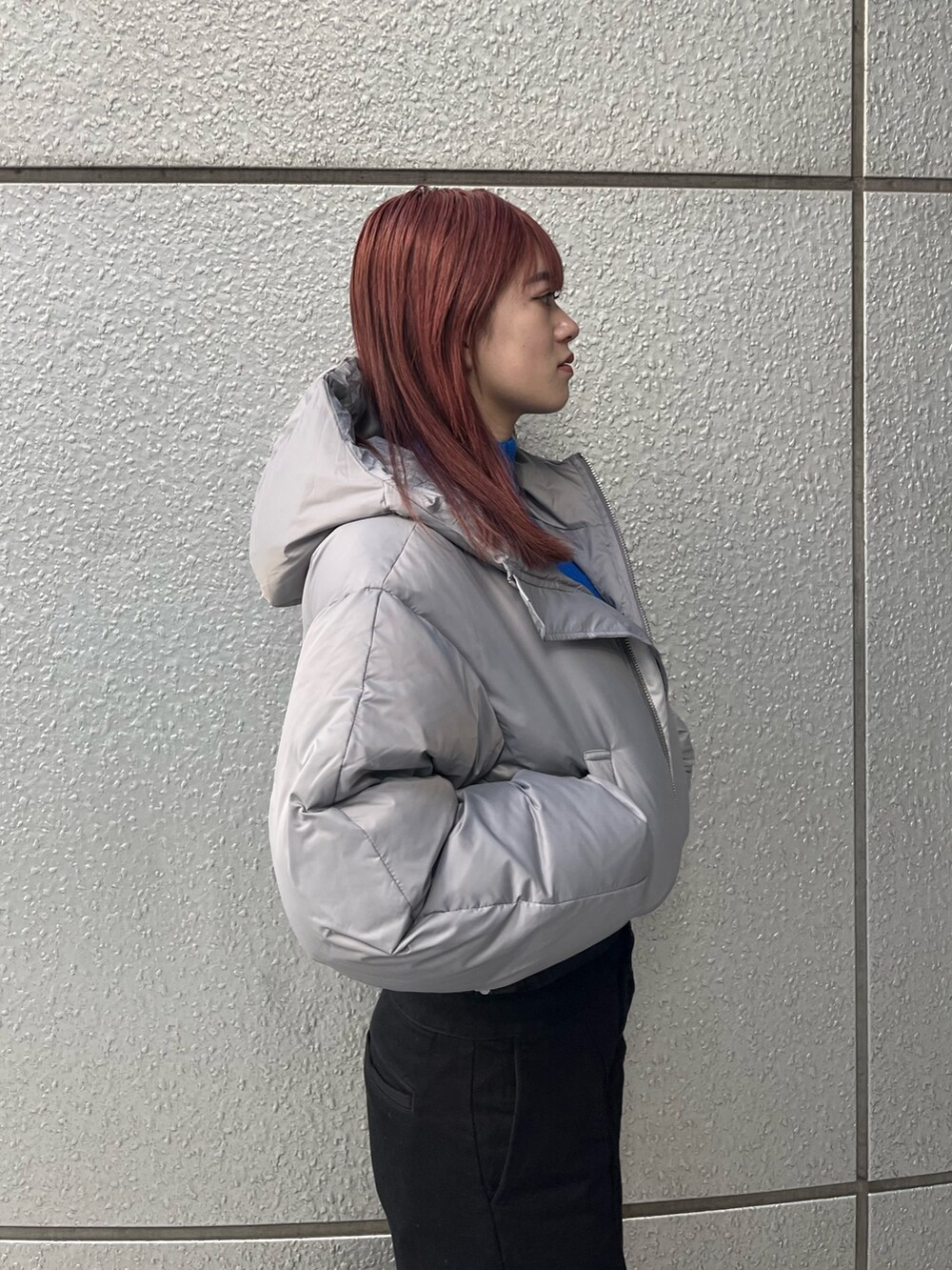 ブラック系のデニムパンツ、ブルー系のニット/セーター、グレー系のダウンジャケット/コートを着用したレディースの冬コーディネートの6枚目の写真