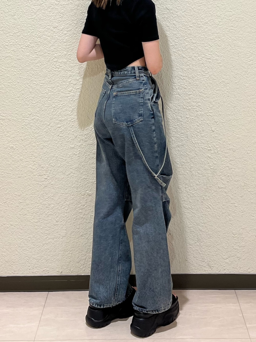 ブルー系のデニムパンツ、ブラック系のTシャツ/カットソー、ブラック系のサンダルを着用したレディースの夏コーディネートの7枚目の写真