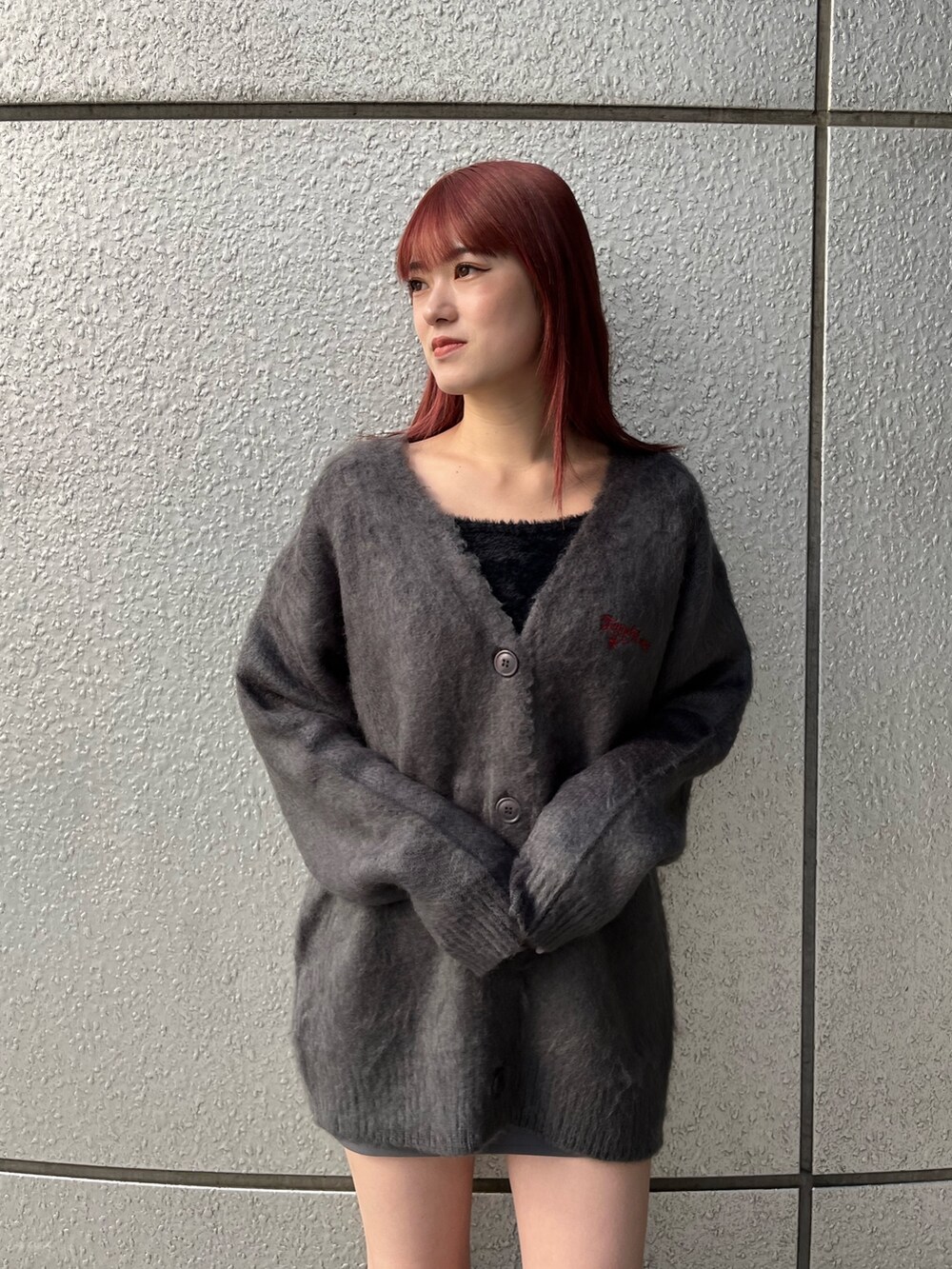 グレー系のカーディガン/ボレロ、グレー系のスカート、ブラック系のブーツを着用したレディースの秋コーディネートの6枚目の写真