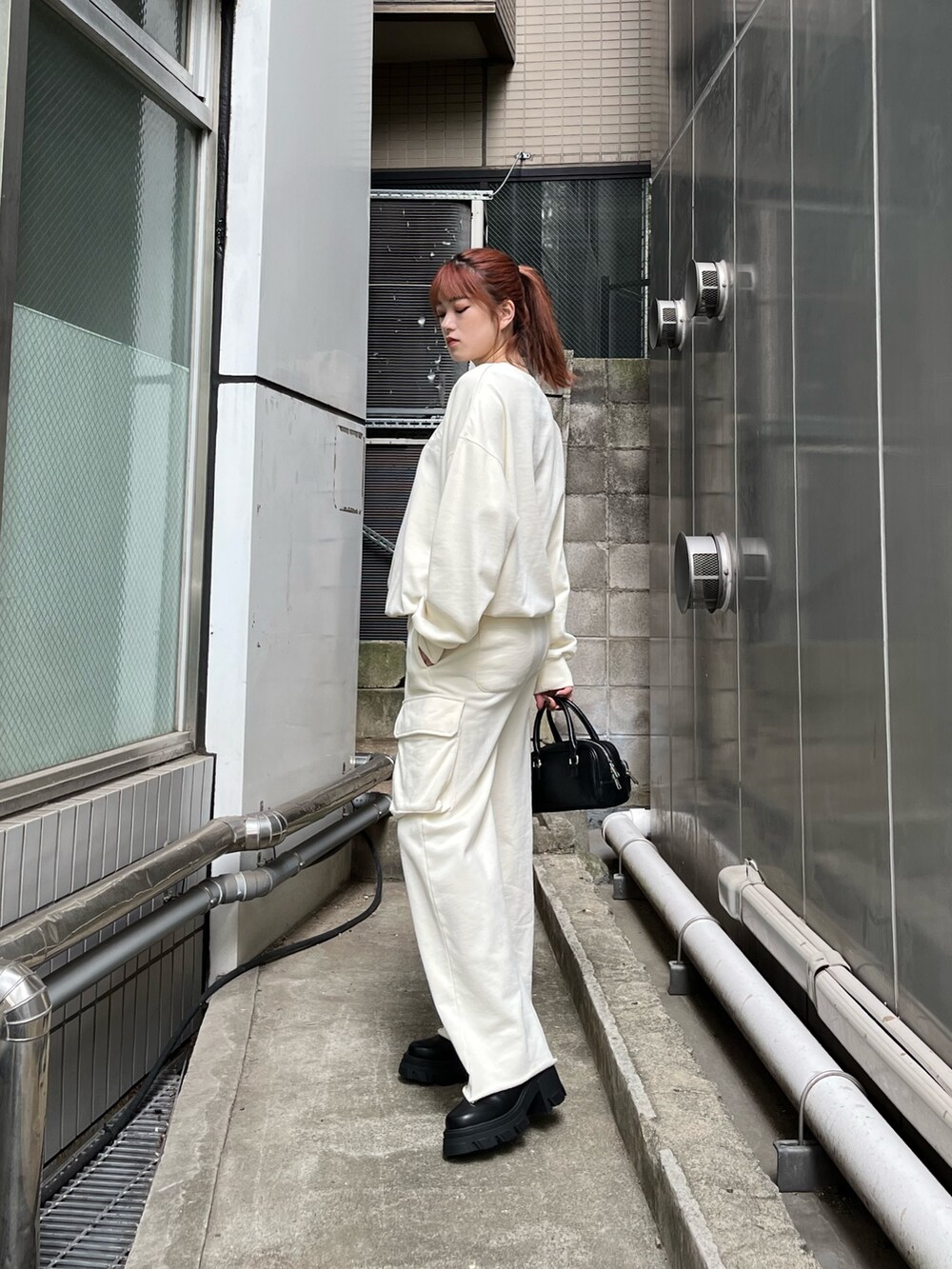 ホワイト系のTシャツ/カットソー、ホワイト系のその他パンツ、ブラック系のブーツを着用したレディースの秋コーディネートの3枚目の写真