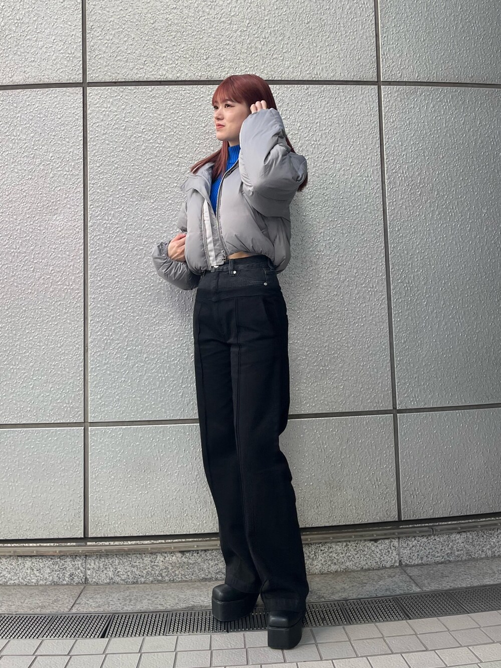 ブラック系のデニムパンツ、ブルー系のニット/セーター、グレー系のダウンジャケット/コートを着用したレディースの冬コーディネートの4枚目の写真