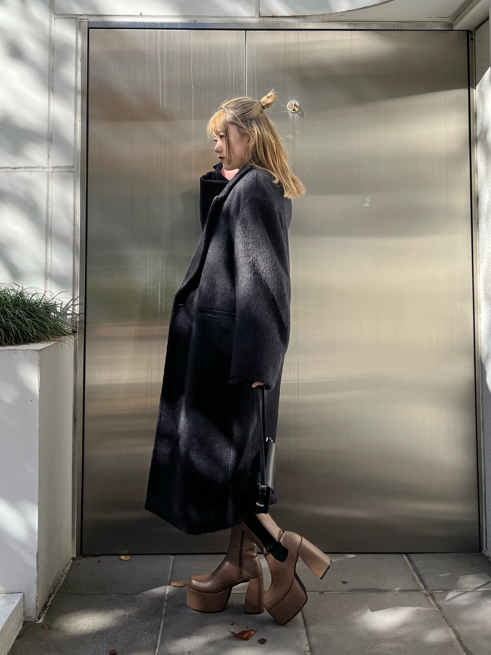 その他のニット/セーター、ブラック系のスカート、ブラウン系のブーツを着用したレディースの冬コーディネートの2枚目の写真