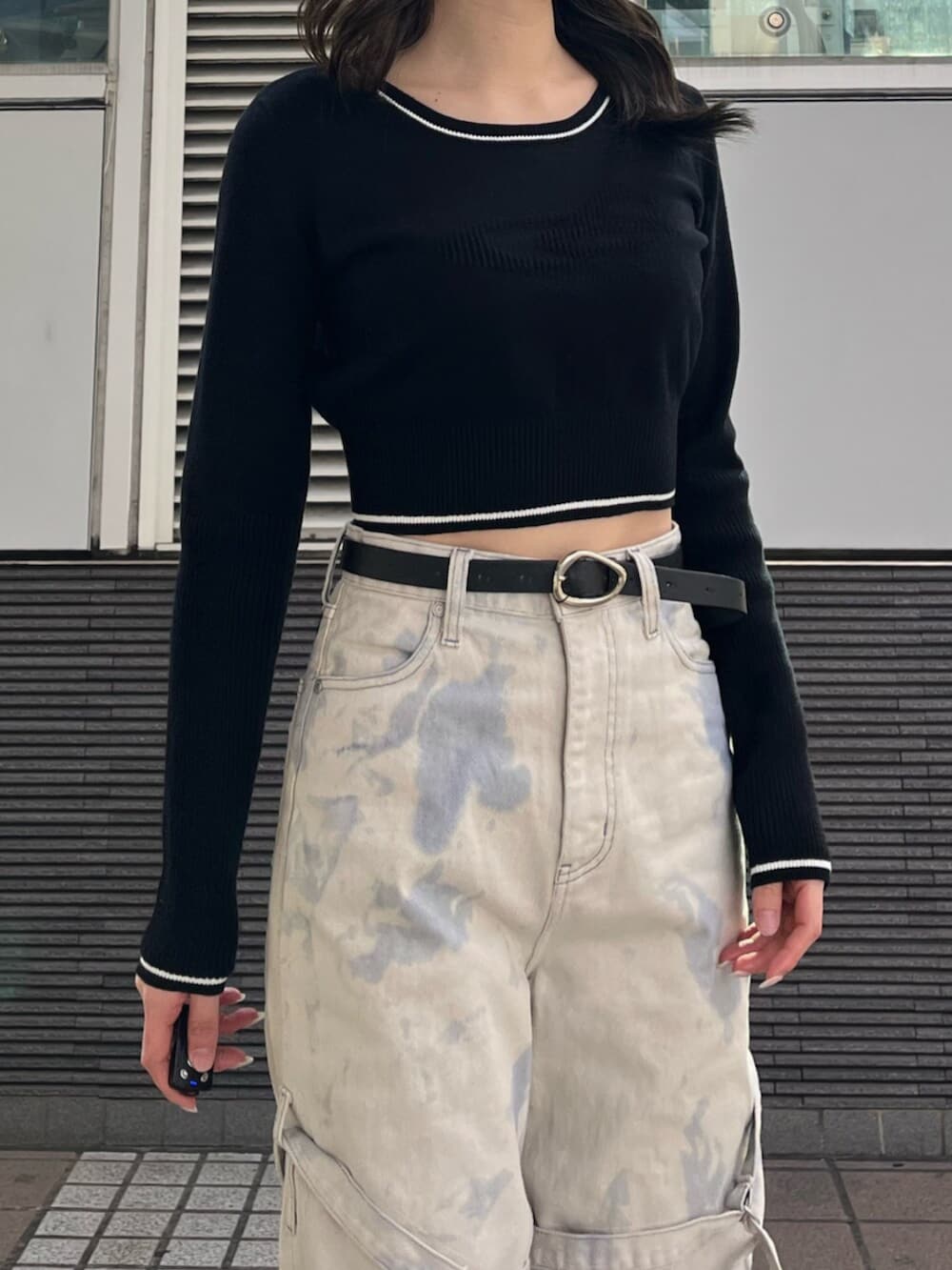 ブラック系のスニーカー、ホワイト系のデニムパンツ、ブラック系のニット/セーターを着用したレディースの冬コーディネートの6枚目の写真