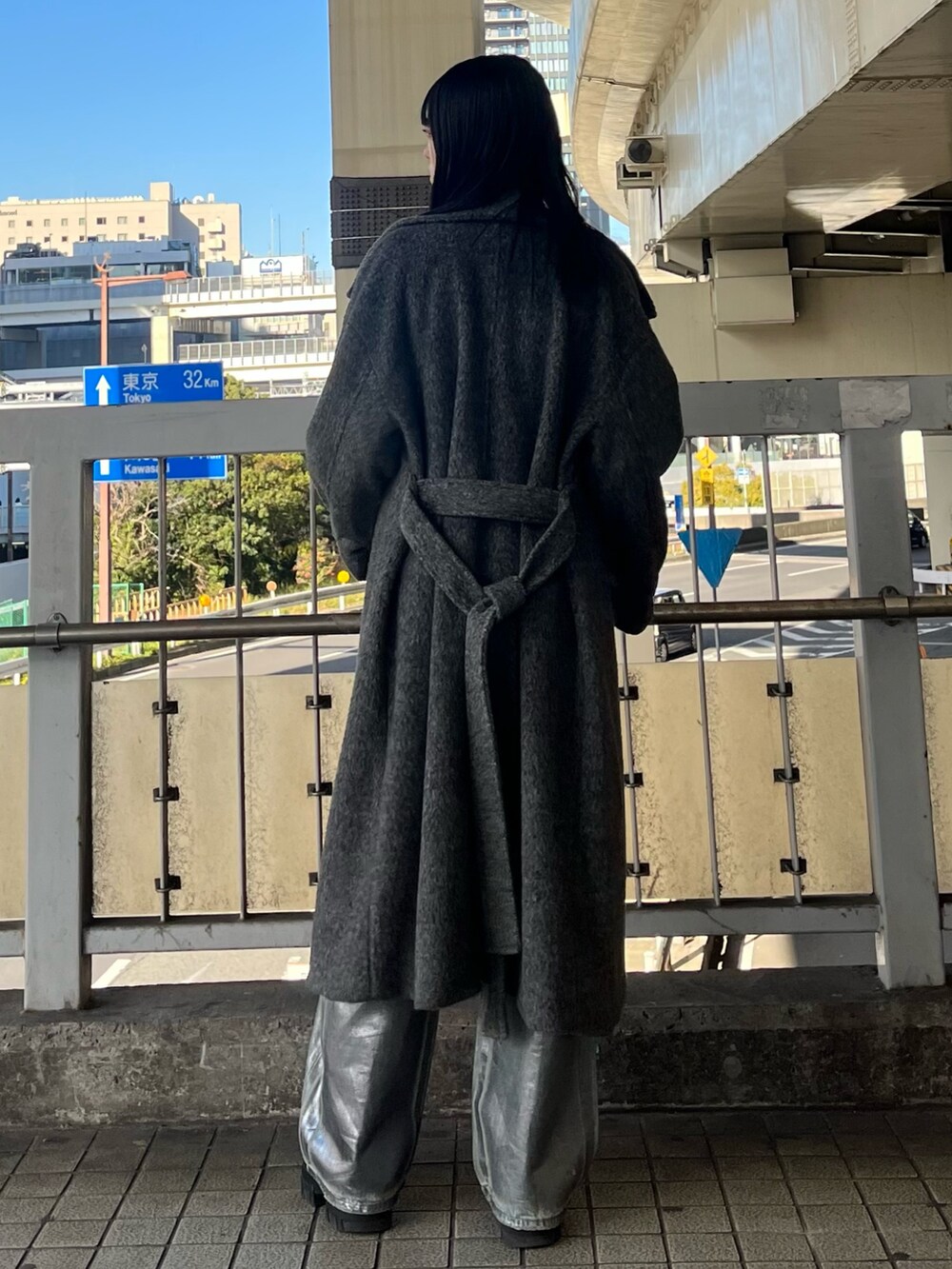 ブラック系のブーツ、ブラック系のニット/セーター、ブルー系のデニムパンツを着用したレディースの冬コーディネートの4枚目の写真