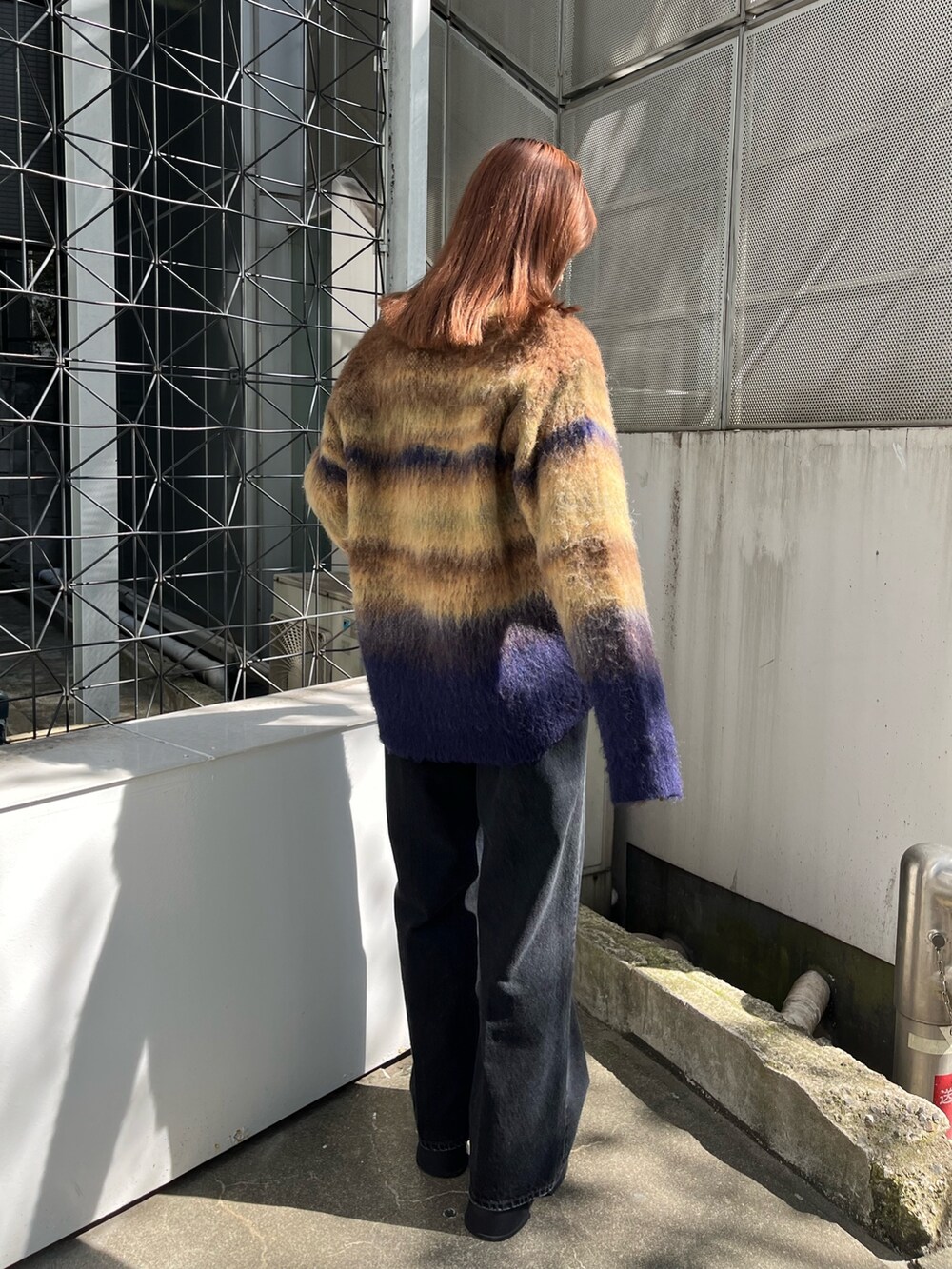 ブラック系のブーツ、ブラック系のデニムパンツ、グリーン系のカーディガン/ボレロを着用したレディースの秋コーディネートの4枚目の写真