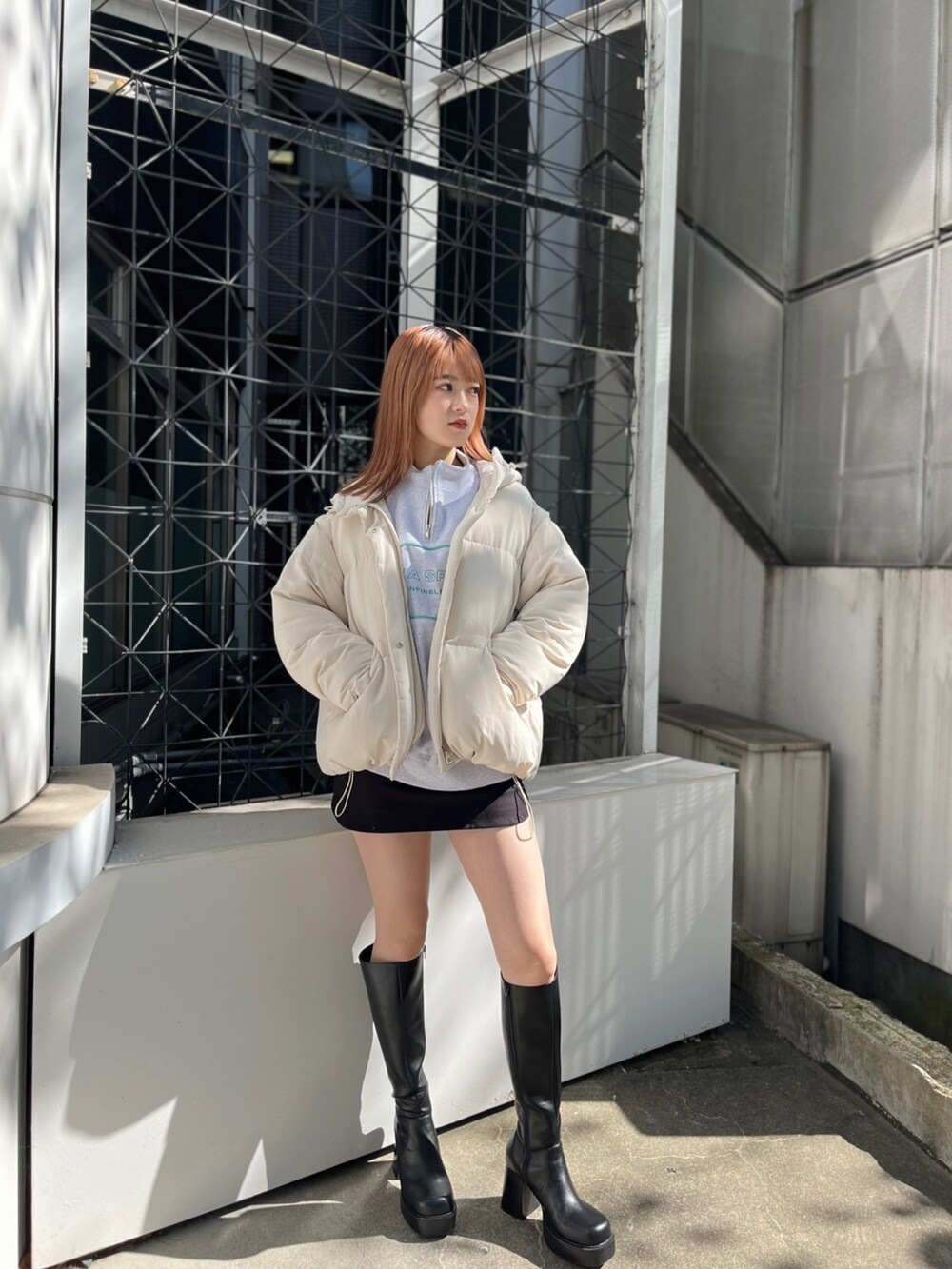 グレー系のスウェット、ホワイト系のブルゾン、ブラック系のスカートを着用したレディースの秋コーディネートの3枚目の写真