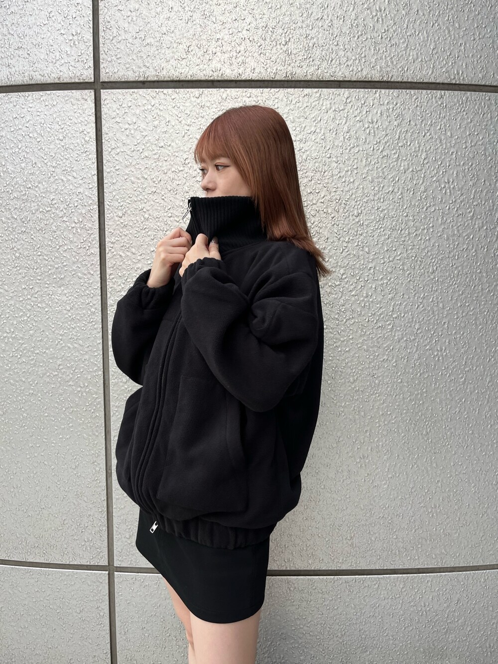 ブラック系のスカート、ブラック系のブーツ、ブラック系のブルゾンを着用したレディースの秋コーディネートの6枚目の写真