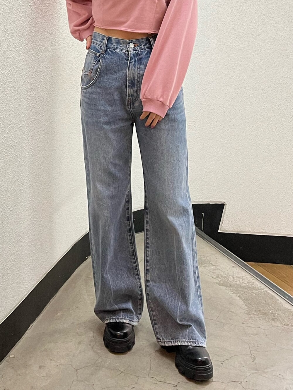 ブルー系のデニムパンツ、ブラック系のブーツ、ピンク系のスウェットを着用したレディースの冬コーディネートの6枚目の写真