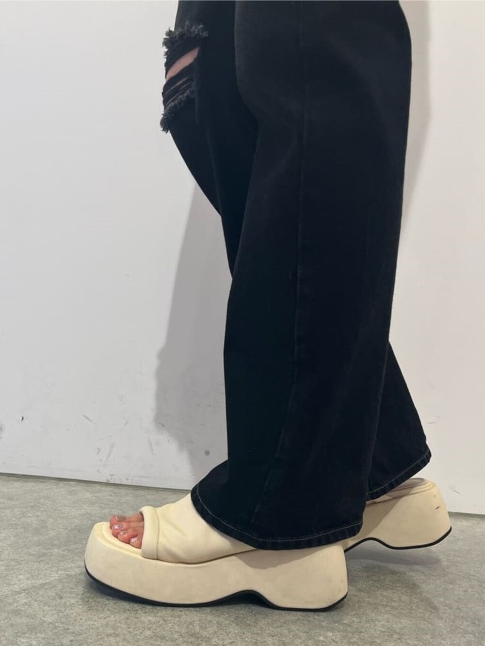 ホワイト系のサンダル、ブラック系のデニムパンツ、その他のアンサンブルを着用したレディースの夏コーディネートの7枚目の写真