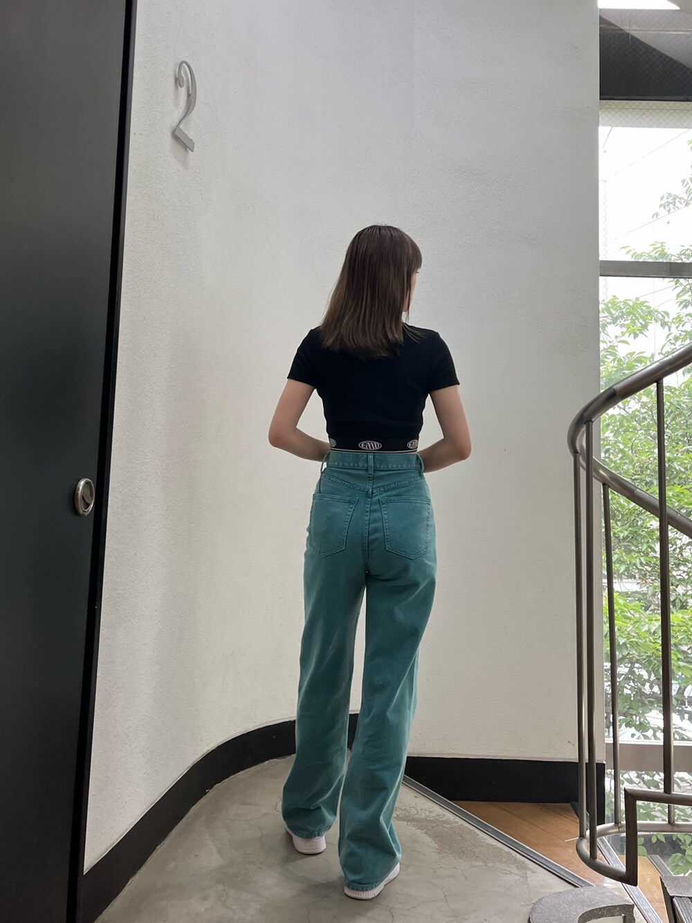 グリーン系のデニムパンツ、ブラック系のTシャツ/カットソー、ホワイト系のスニーカーを着用したレディースの夏コーディネートの3枚目の写真