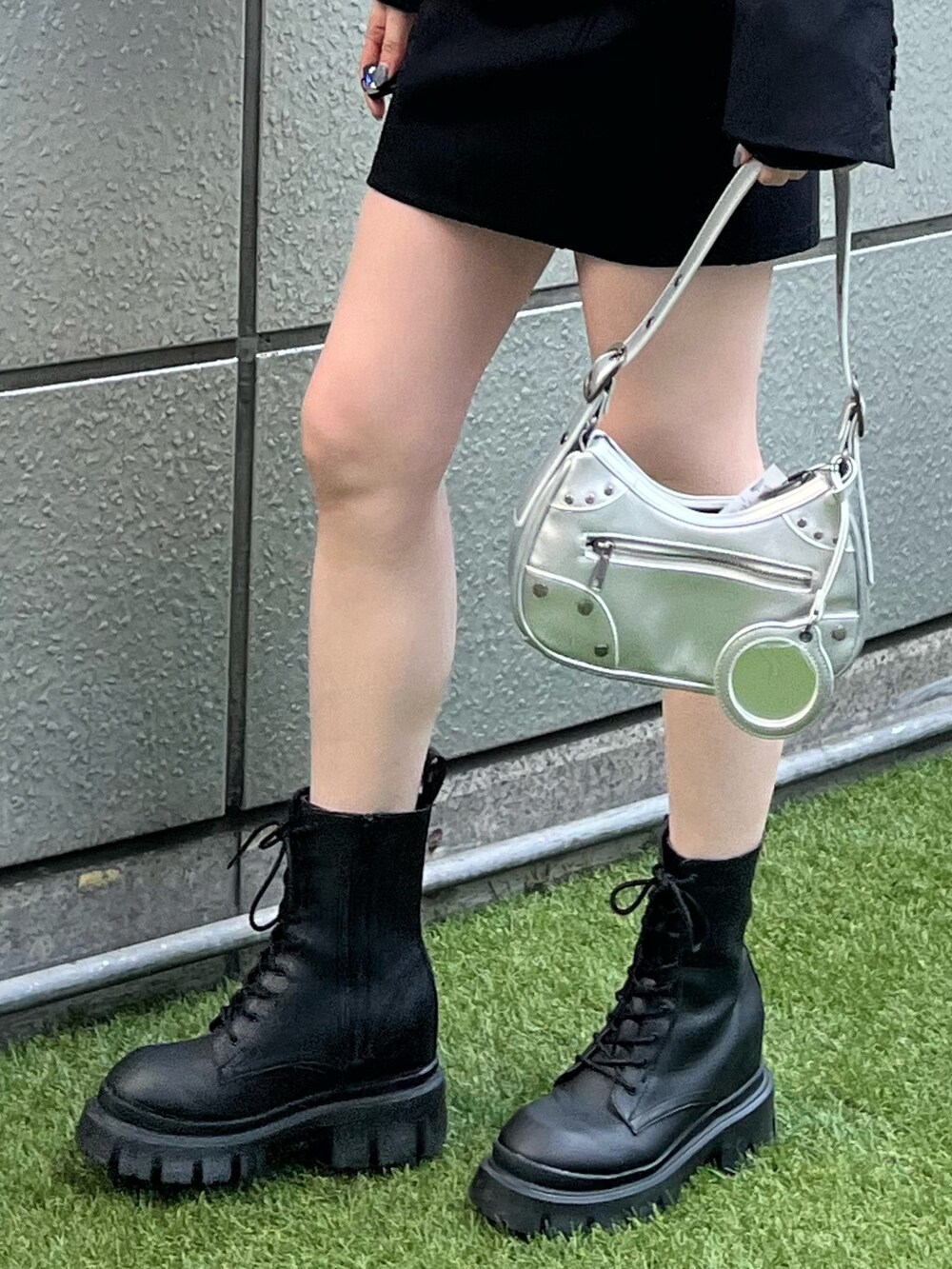 ブラック系のブーツ、シルバー系のハンドバッグ、ブラック系のテーラードジャケットを着用したレディースの春コーディネートの6枚目の写真