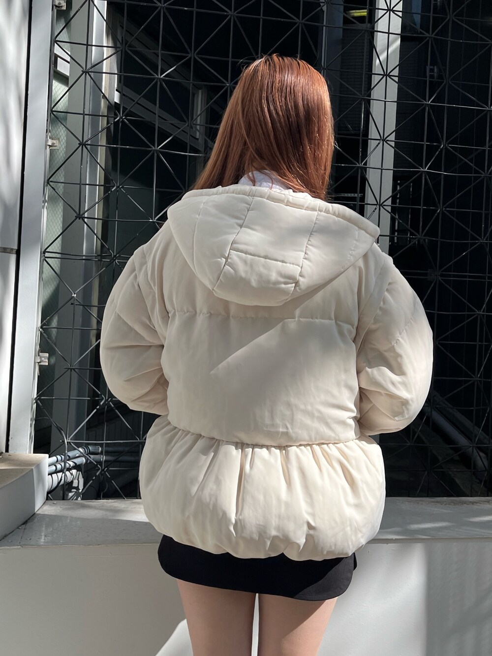 グレー系のスウェット、ホワイト系のブルゾン、ブラック系のスカートを着用したレディースの秋コーディネートの6枚目の写真