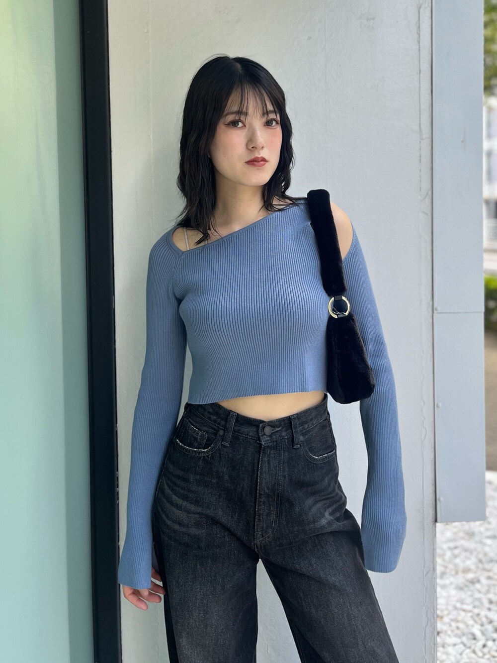 ブラック系のデニムパンツ、ブラック系のブーツ、ブルー系のニット/セーターを着用したレディースの秋コーディネートの6枚目の写真