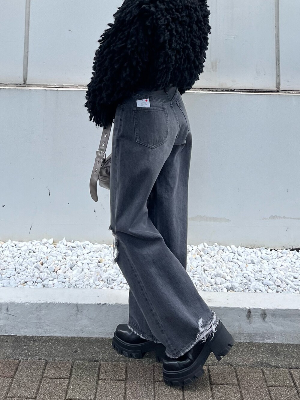 ブラック系のブーツ、グレー系のデニムパンツ、ブラック系のニット/セーターを着用したレディースの秋コーディネートの7枚目の写真