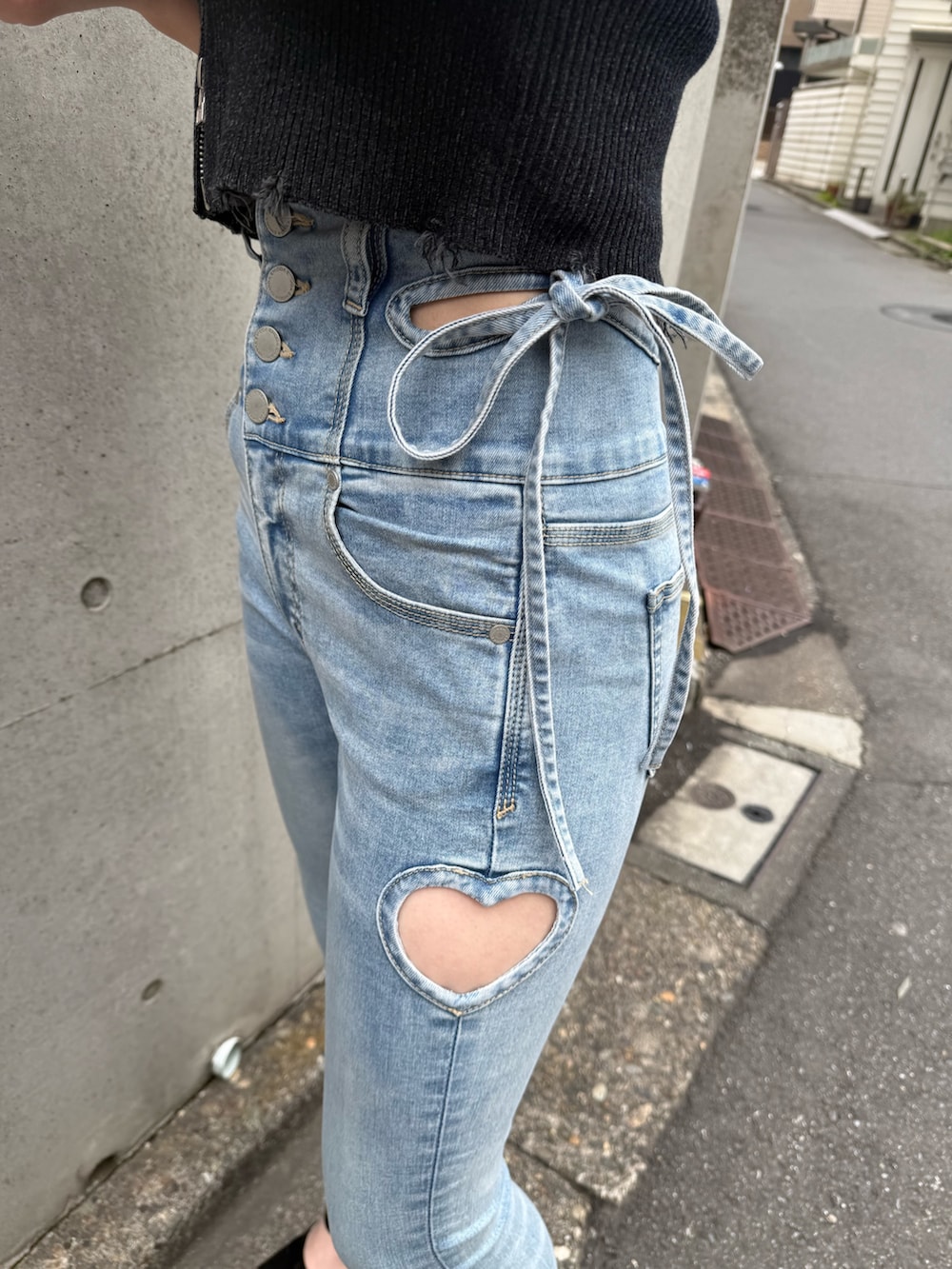 ブルー系のデニムパンツ、ブラック系のサンダル、ブラック系のニット/セーターを着用したレディースの春コーディネートの4枚目の写真