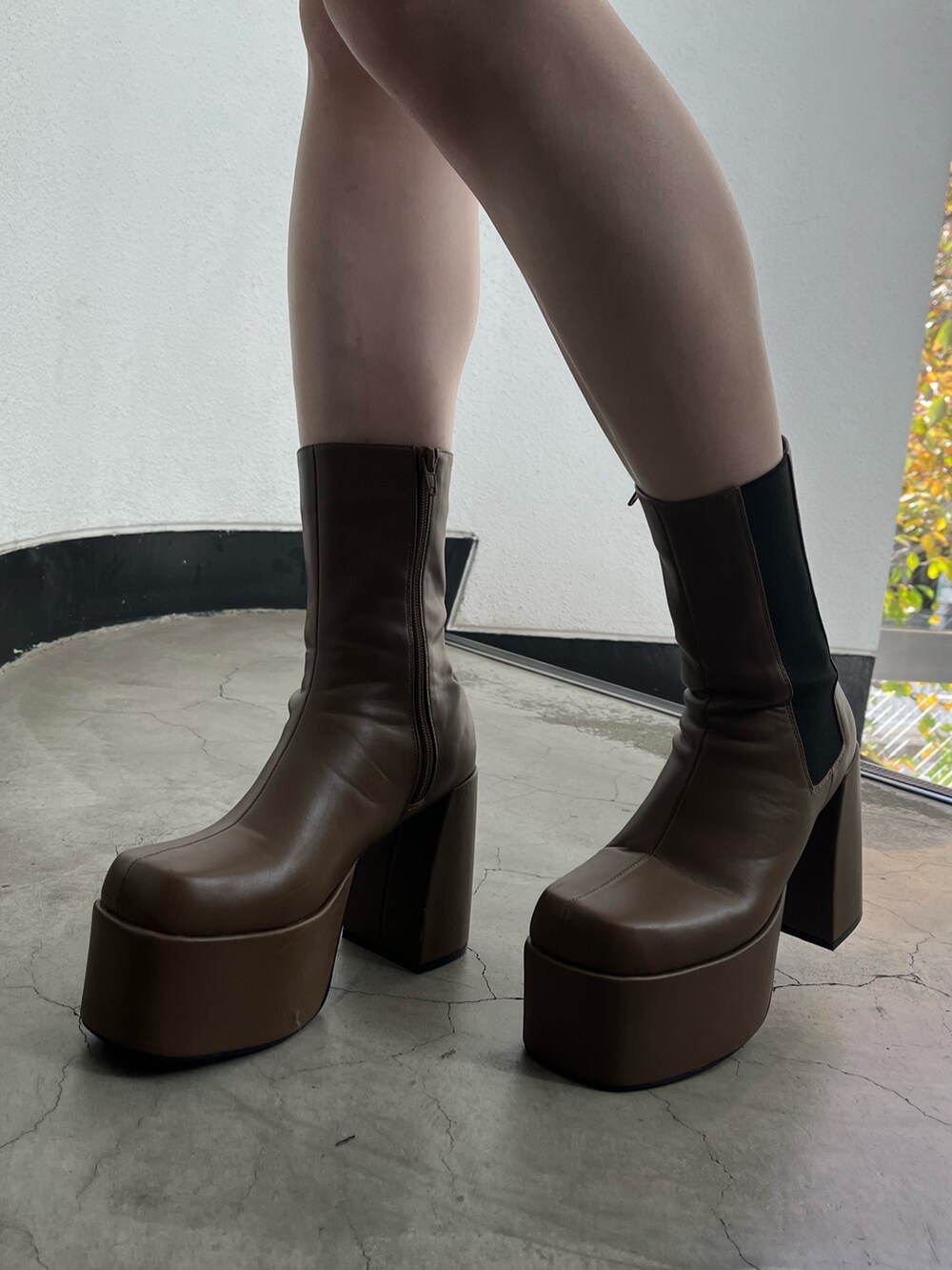 ブラウン系のブーツ、ブラック系のスカート、ブラック系のニット/セーターを着用したレディースの冬コーディネートの6枚目の写真