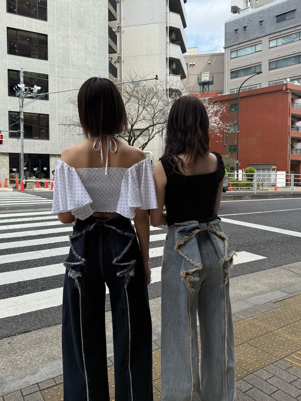 ブルー系のデニムパンツ、ブラウン系のスニーカーを着用したレディースの春コーディネートの2枚目の写真