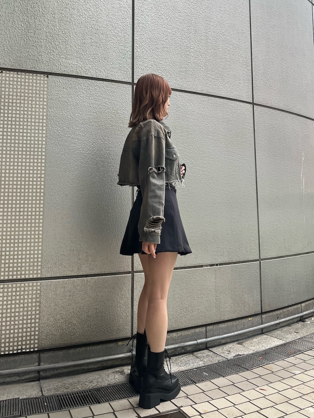 ブラック系のニット/セーター、グレー系のスカート、ブラック系のブーツを着用したレディースの冬コーディネートの4枚目の写真