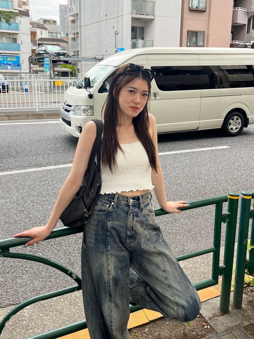 ブルー系のデニムパンツ、ブラウン系のスニーカー、ホワイト系のキャミソールを着用したレディースの春コーディネートの3枚目の写真