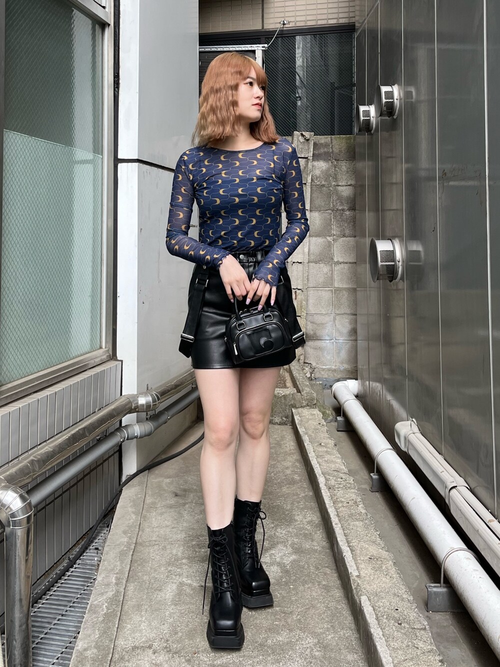 ブラック系のブーツ、ブラック系のスカート、その他のTシャツ/カットソーを着用したレディースの冬コーディネートの2枚目の写真