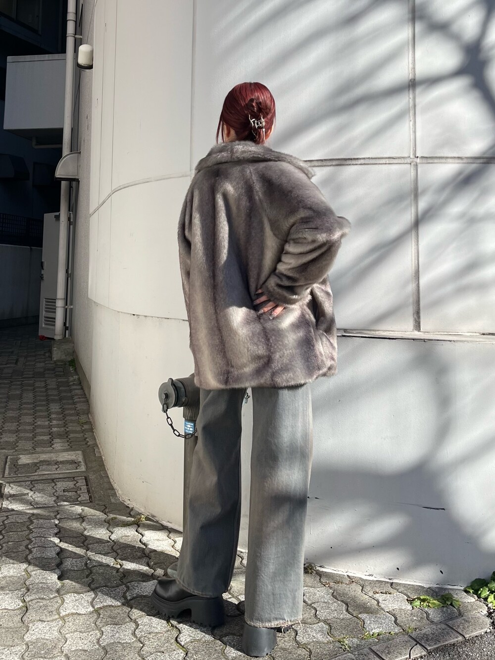 グレー系のその他アウター、グレー系のデニムパンツ、ブラック系のニット/セーターを着用したレディースの冬コーディネートの5枚目の写真