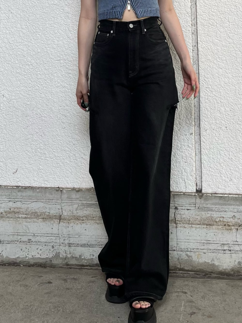 ブラック系のデニムパンツ、ブルー系のニット/セーター、ブラック系のサンダルを着用したレディースの夏コーディネートの7枚目の写真