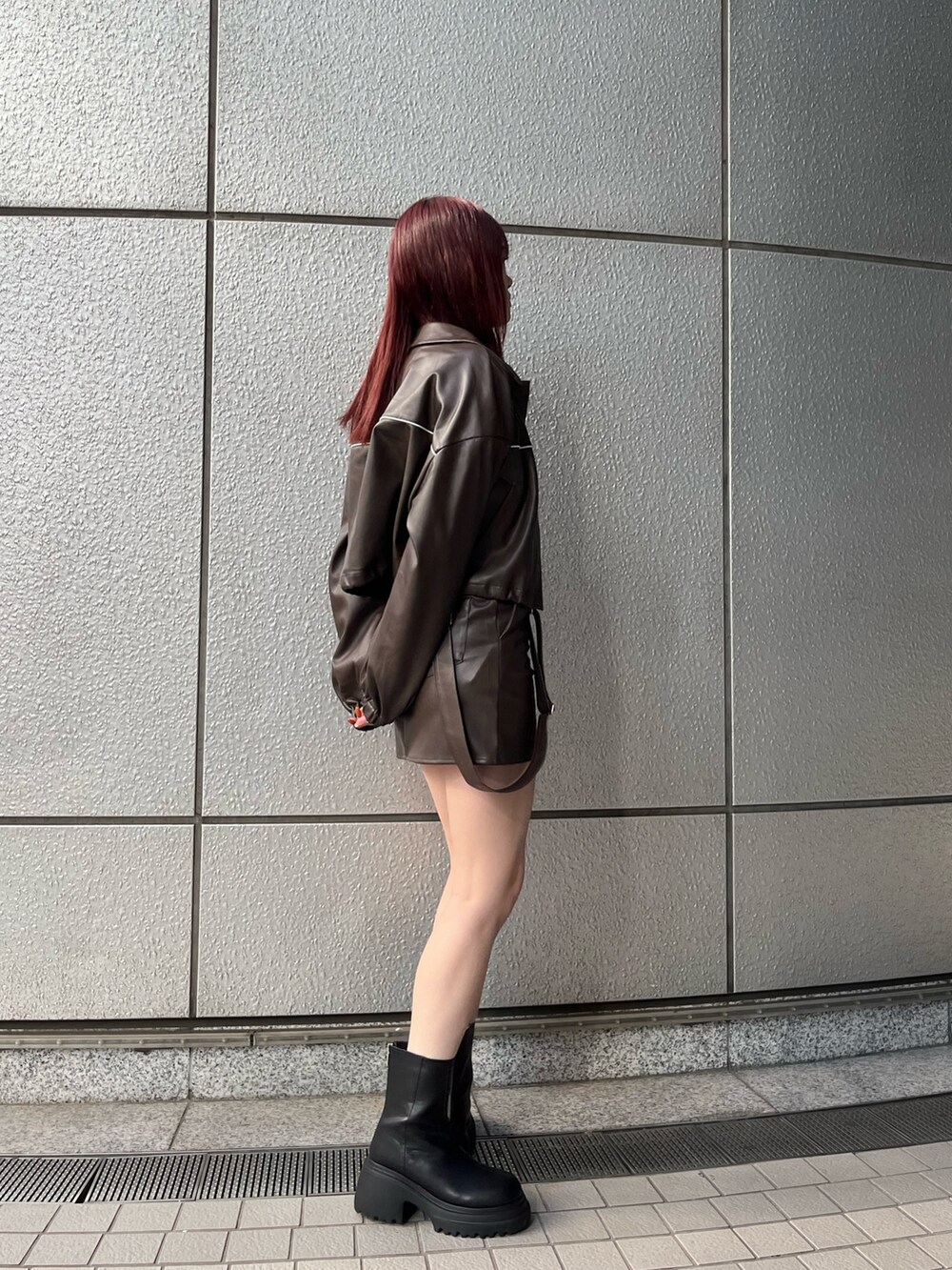 ブラウン系のスカート、ブラック系のニット/セーター、ブラウン系のブルゾンを着用したレディースの冬コーディネートの3枚目の写真