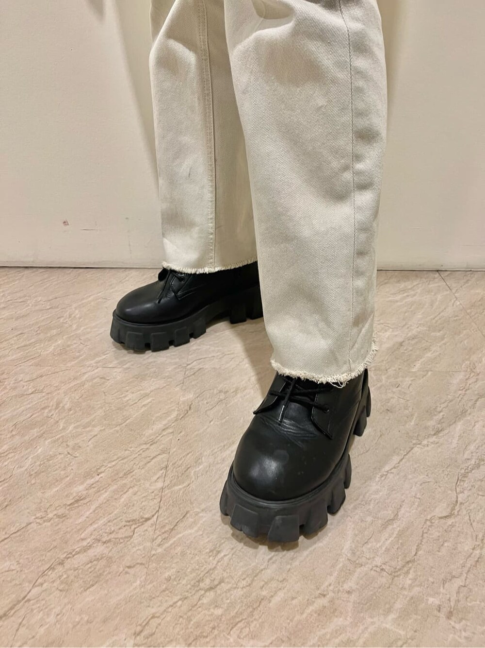 ブラック系のブーツ、ホワイト系のデニムジャケット、その他のポロシャツを着用したレディースの春コーディネートの7枚目の写真